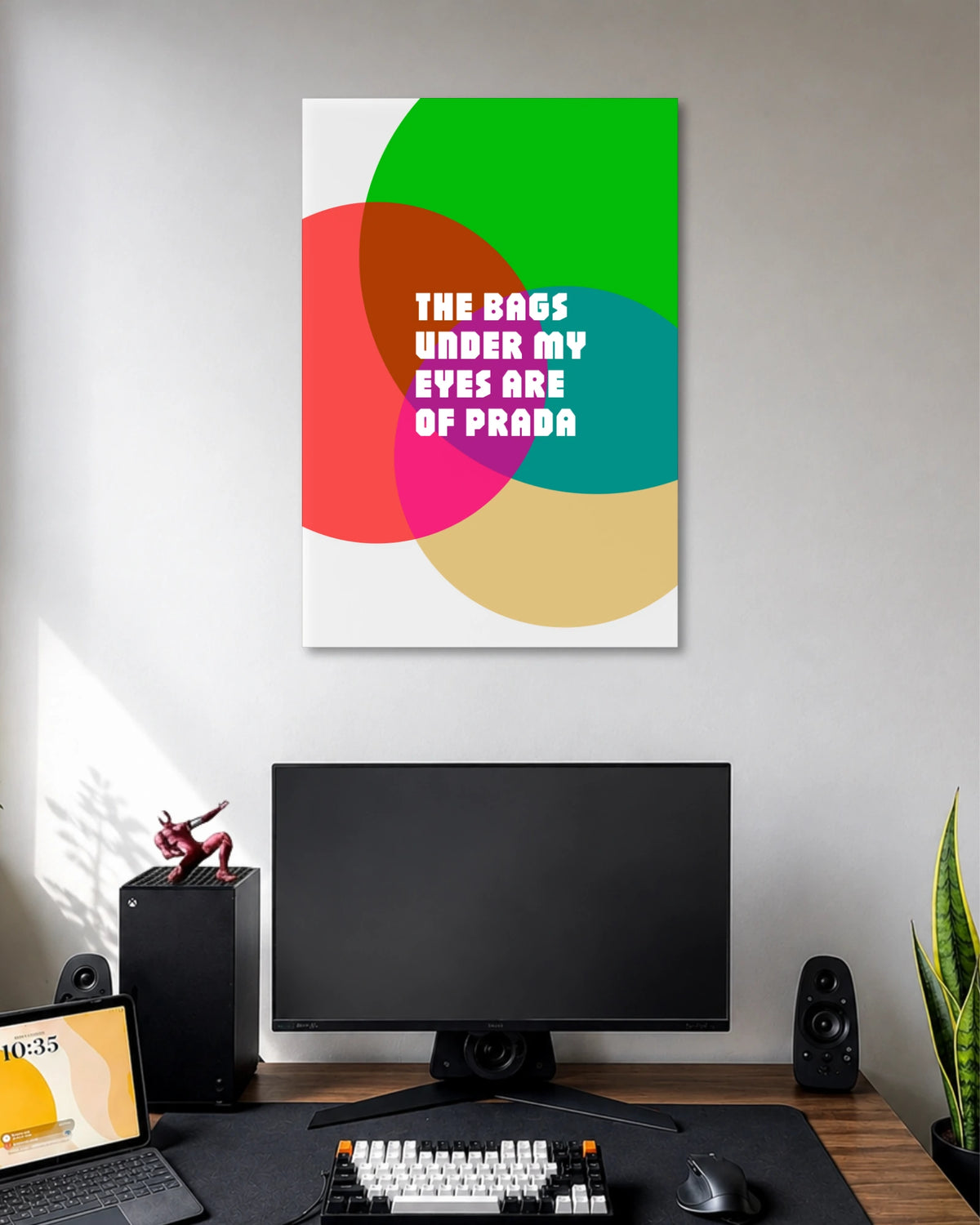 The Bags Under My Eyes Are of Prada Poster poster design: The phrase “The Bags Under My Eyes Are of Prada” takes centre stage in bold white lettering. Overlapping circles in green, red, pink, teal, and beige create a colourful pop art design with a fashion inspired sense of humour.