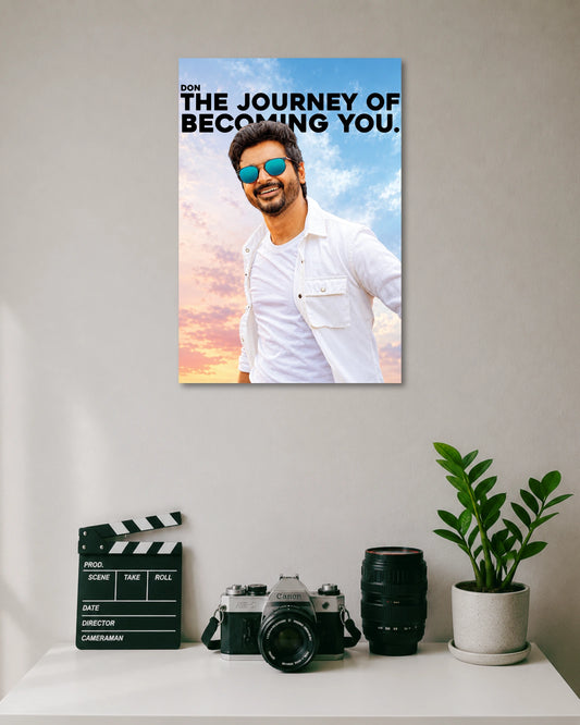 Don The Journey of Becoming You Sivakarthikeyan Poster poster design: Sivakarthikeyan appears in a white outfit and blue sunglasses against a pastel sky, alongside the bold quote “The Journey of Becoming You.” The design combines Tamil cinema style with an uplifting message for your walls.