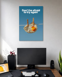 Don't Be Afraid to Try Again Motivational Poster poster design: Featuring a fried egg hanging from a clothesline against a clear blue background, this quirky motivational poster carries the message "Don't be afraid to try again." Its unexpected visual makes encouragement feel playful and memorable.