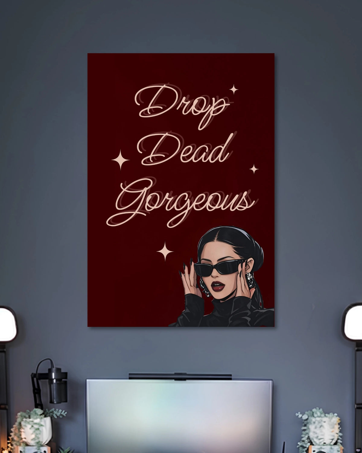 Burgundy poster with the words Drop Dead Gorgeous in elegant white script above a woman wearing black sunglasses.