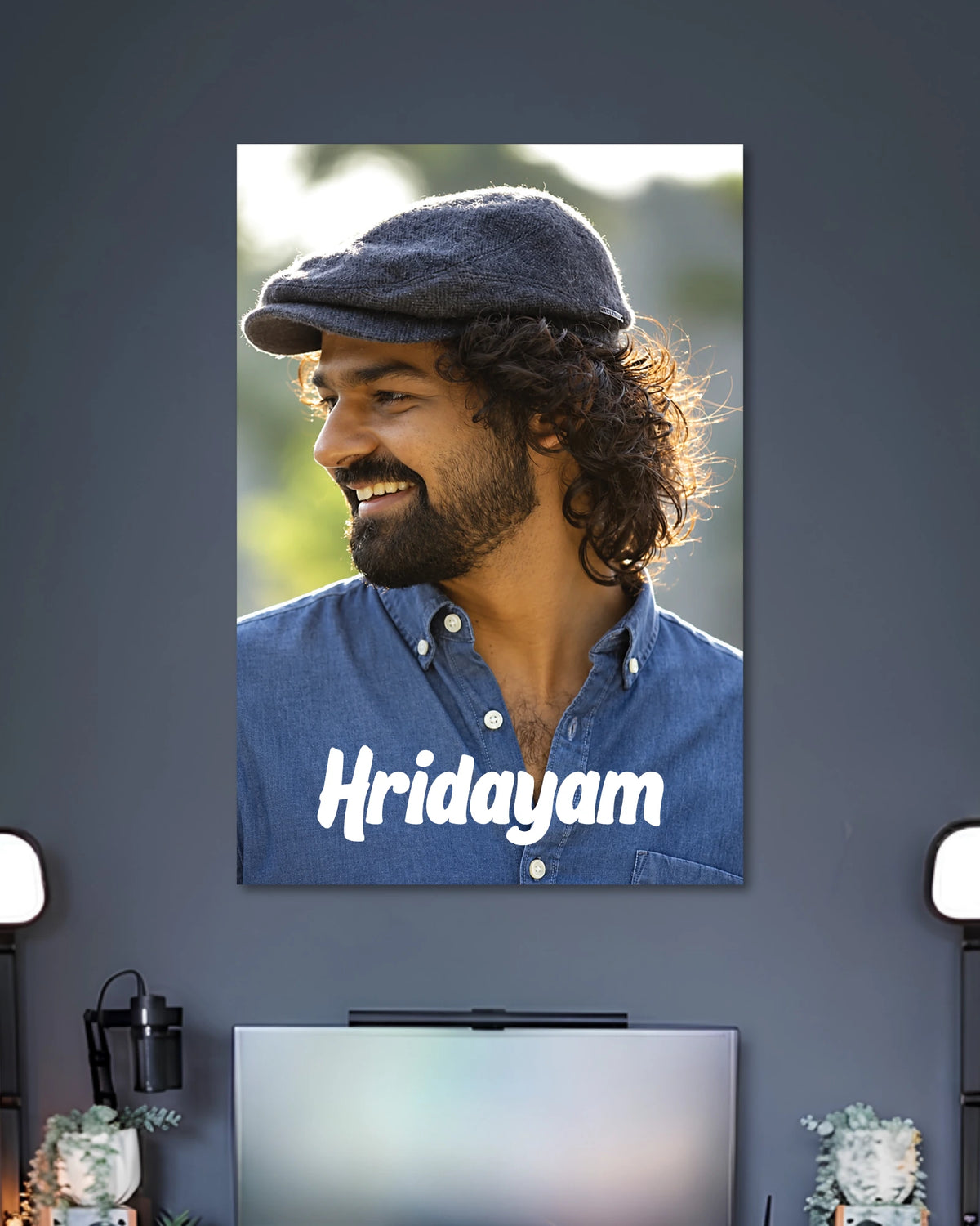 Hridayam Movie Poster Featuring Pranav Mohanlal poster design: Pranav Mohanlal wears a flat cap and blue shirt in this portrait inspired by Hridayam. White lettering across the lower section displays the film title, giving the design a clean, understated look for Malayalam cinema fans.