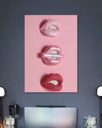 Pink poster with three stacked close-ups of glossy lips, including a silver lip piercing and a metallic object held between lips.