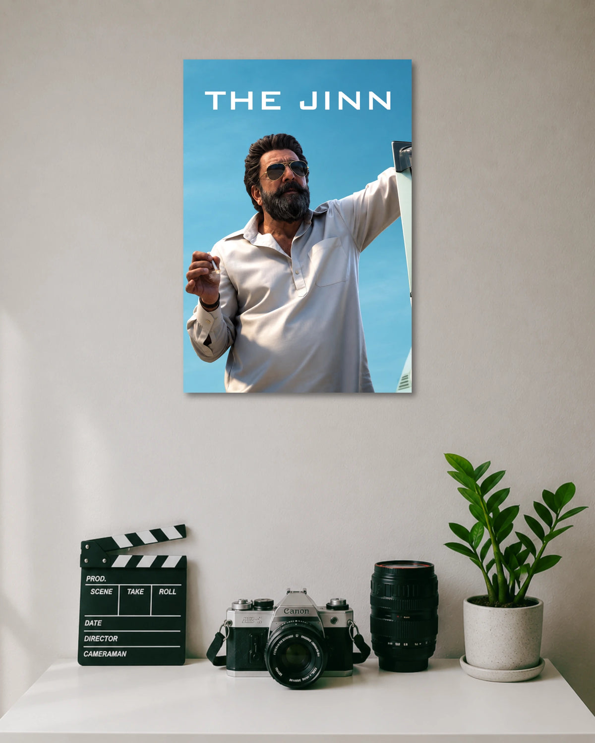Sanjay Dutt The Jinn Poster poster design: Bring the intense presence of Sanjay Dutt as The Jinn from Dhurandhar to your walls. Set against a clear blue sky, the poster features his bearded look, aviator sunglasses and white outfit for a bold cinematic display.