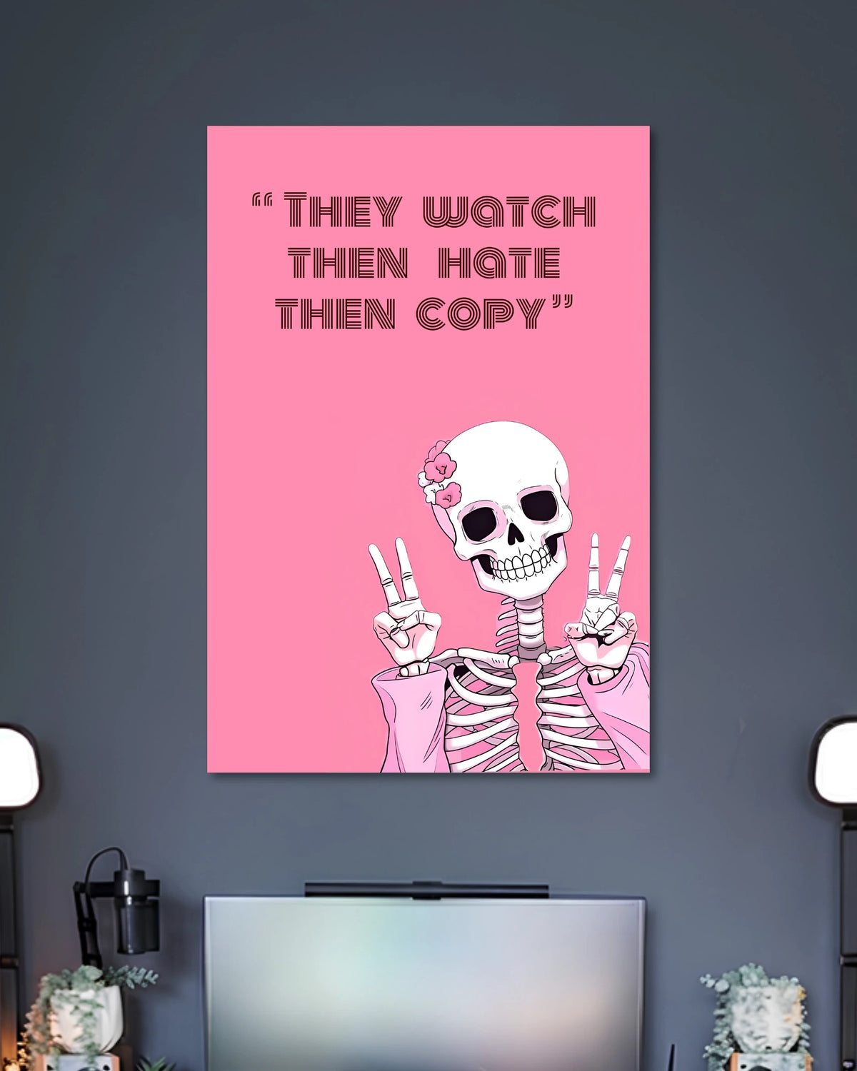 Hot-pink poster with a smiling white skeleton raising both hands in peace signs under THEY WATCH THEN HATE THEN COPY text.
