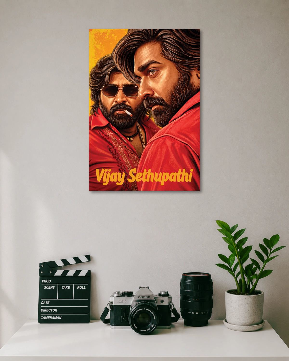 Vijay Sethupathi Illustrated Portrait Poster poster design: Vijay Sethupathi appears in a detailed illustrated portrait wearing a red shirt, with another portrait of the actor in sunglasses behind him. Rich red and golden tones give the artwork a bold, cinematic look for fans.